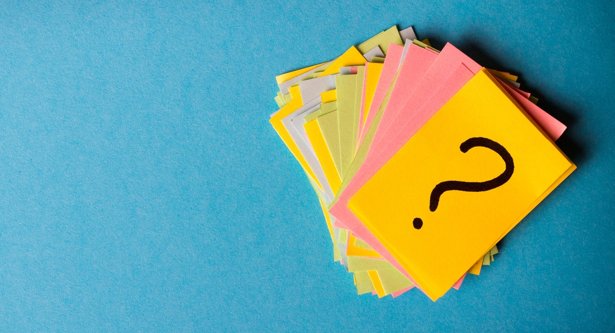 Stack of colorful paper notes, top note has a question mark